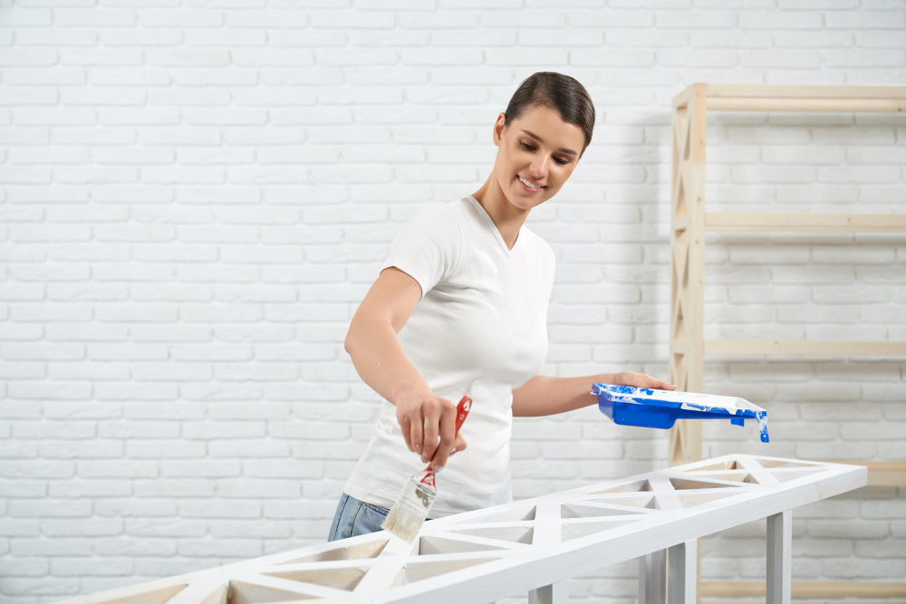 Chica pintando muebles en blanco